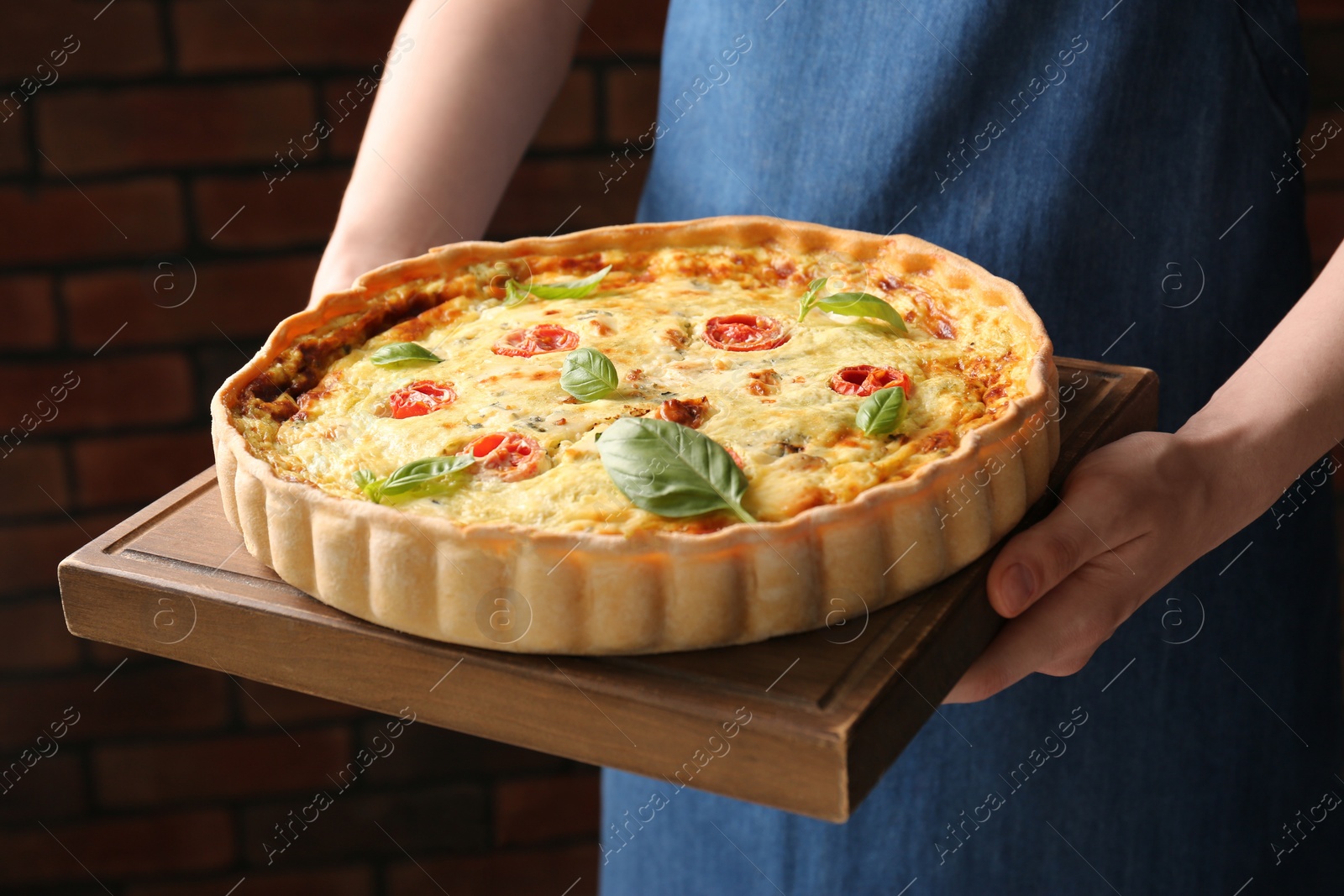 Photo of Woman with delicious homemade cheese quiche indoors, closeup