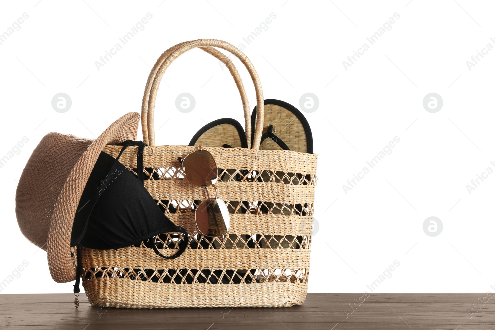 Photo of Set of beach accessories on wooden table, white background