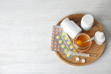 Photo of Tray with different cold remedies on white wooden table, top view. Space for text