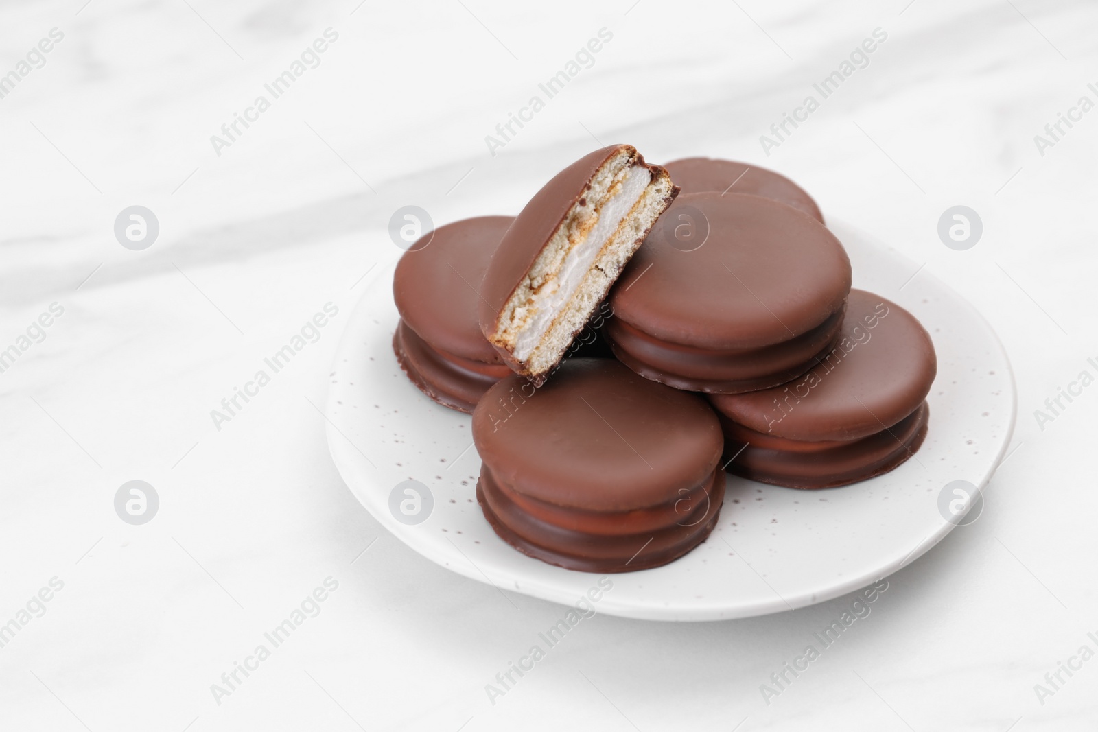 Photo of Saucer with delicious choco pies on white table