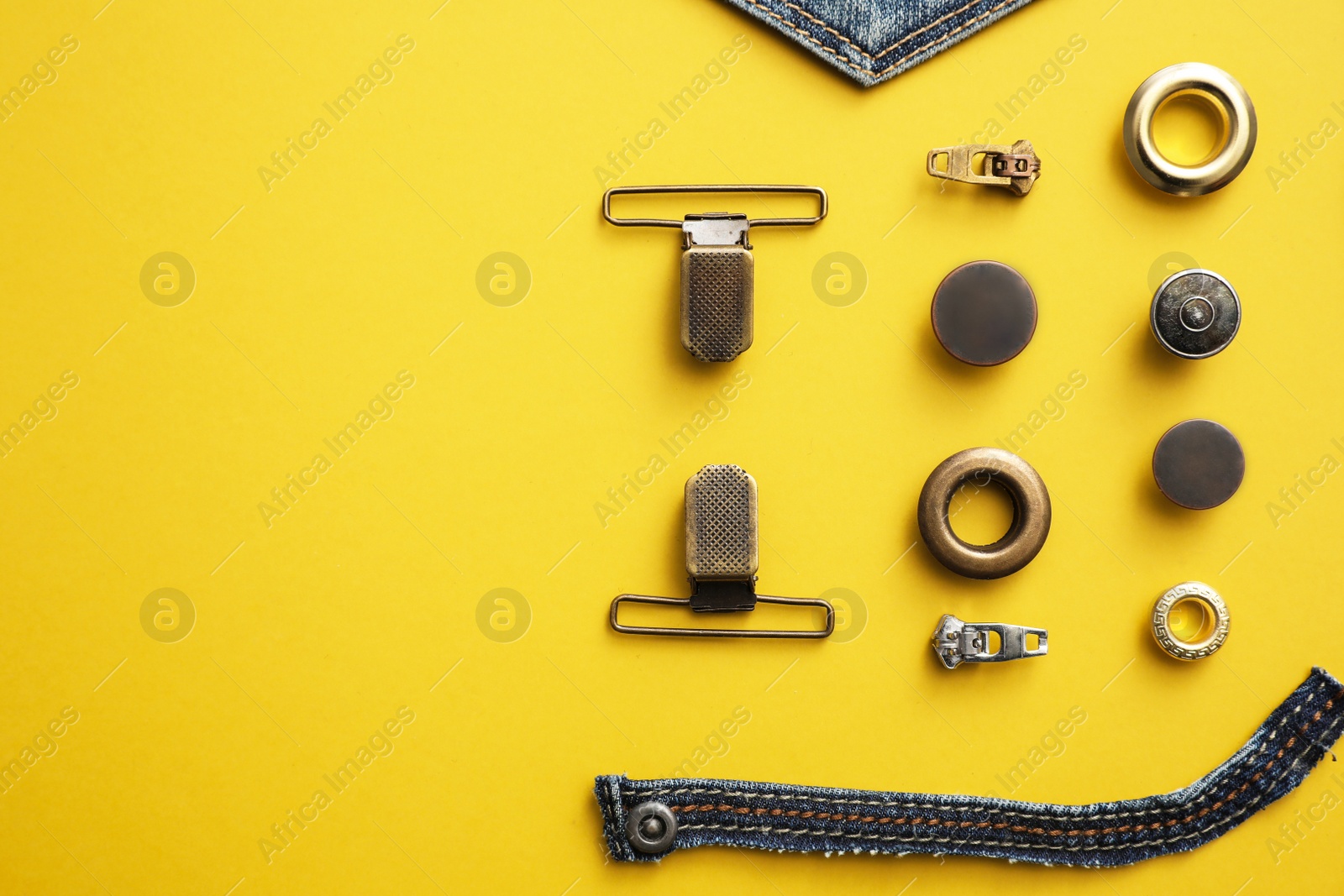 Photo of Flat lay composition with garment accessories and cutting details for jeans on yellow background. Space for text