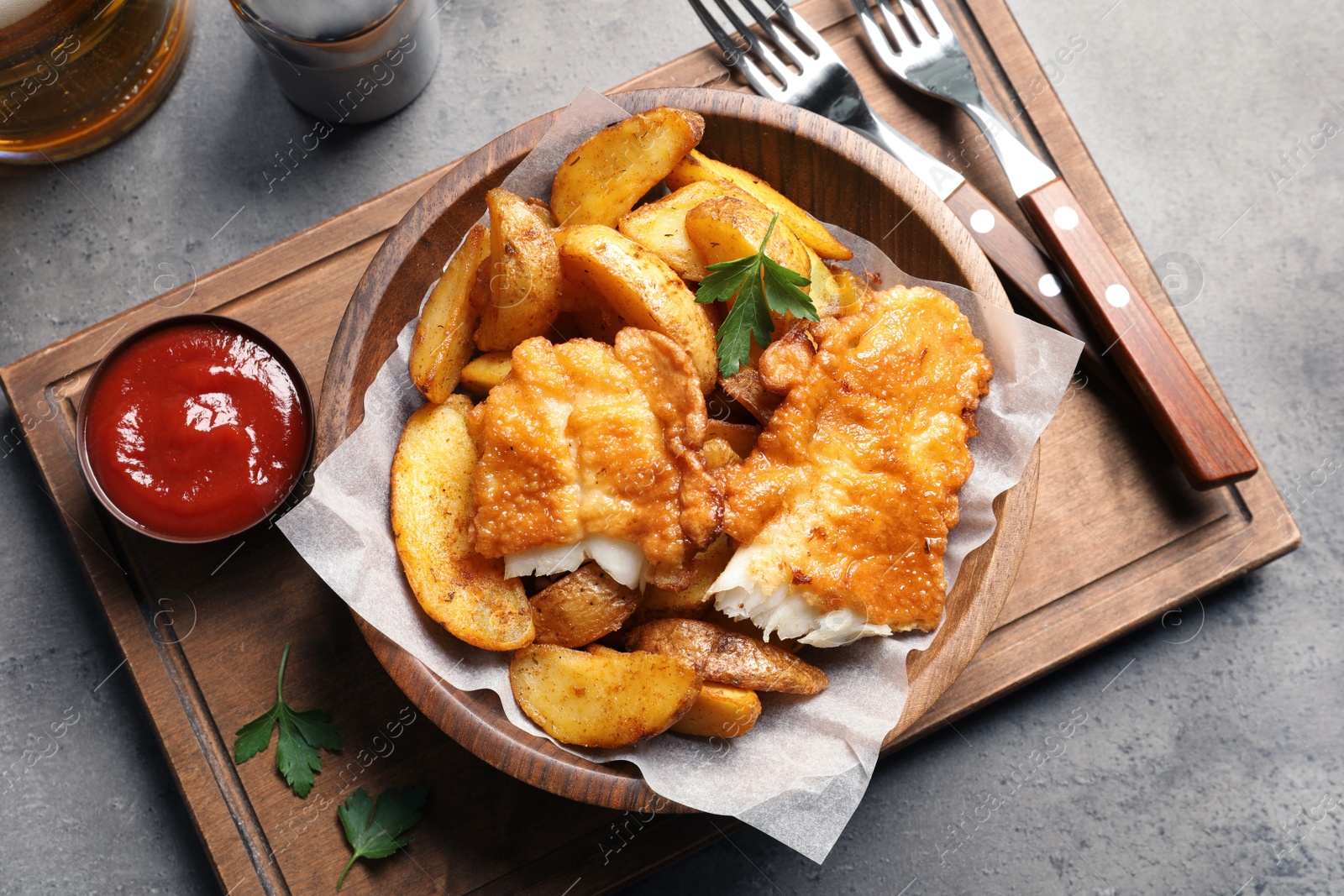 Photo of Tasty British traditional fish and potato chips on table, top view