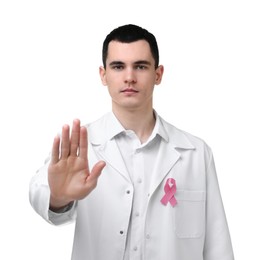 Photo of Mammologist with pink ribbon showing stop gesture on white background. Breast cancer awareness