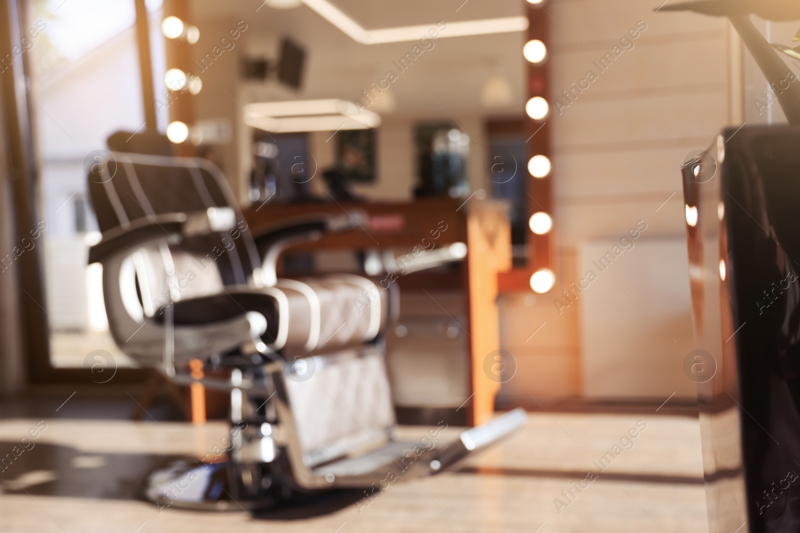 Photo of Blurred view of stylish barbershop interior with hairdresser workplace