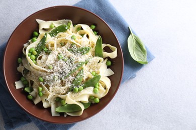 Photo of Delicious pasta with green peas and ingredients on grey table, flat lay. Space for text