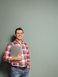 Photo of Portrait of confident man with laptop on color background