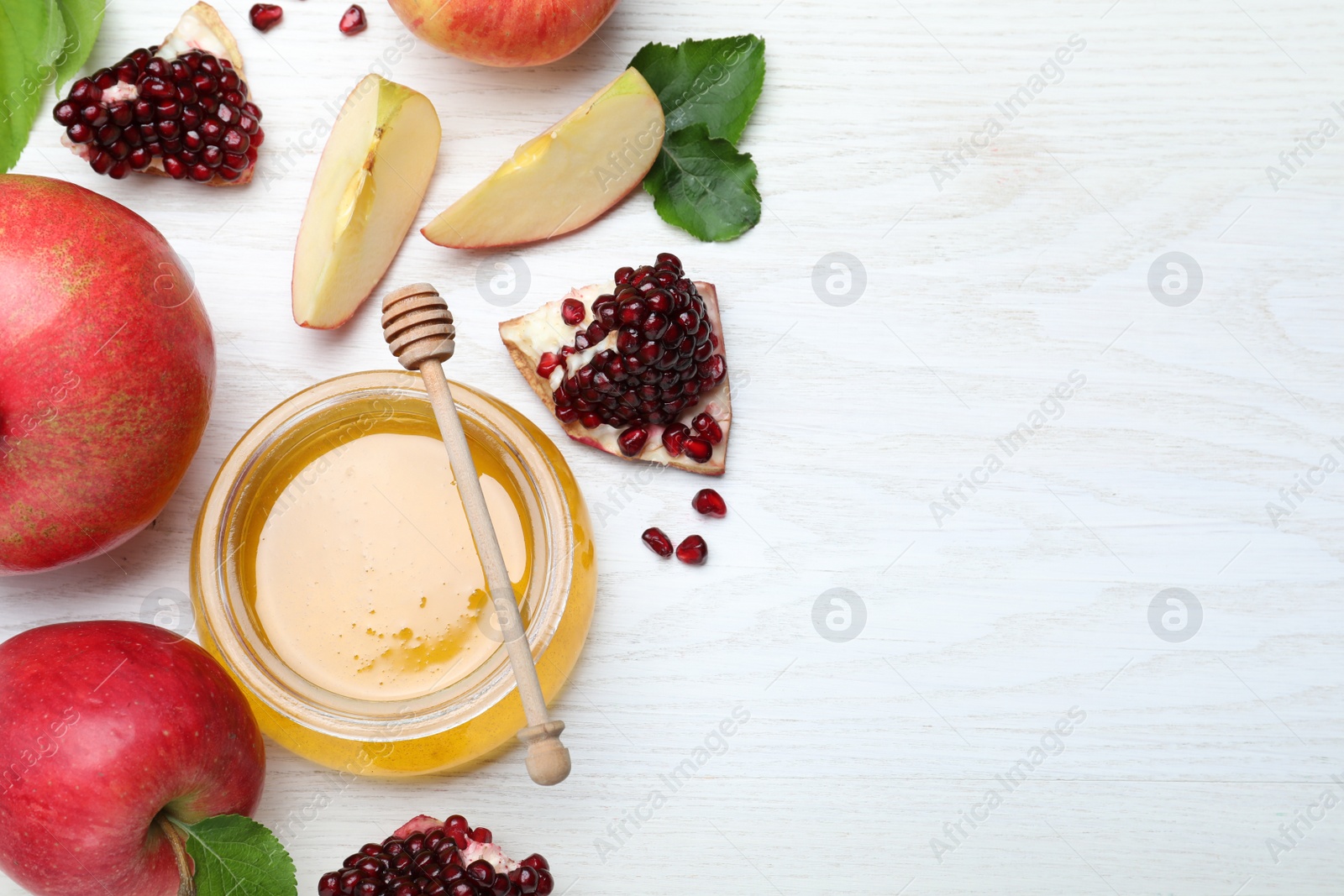 Photo of Honey, pomegranate and apples on white wooden table, flat lay with space for text. Rosh Hashana holiday