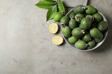 Flat lay composition with fresh green feijoa fruits on light grey table. Space for text