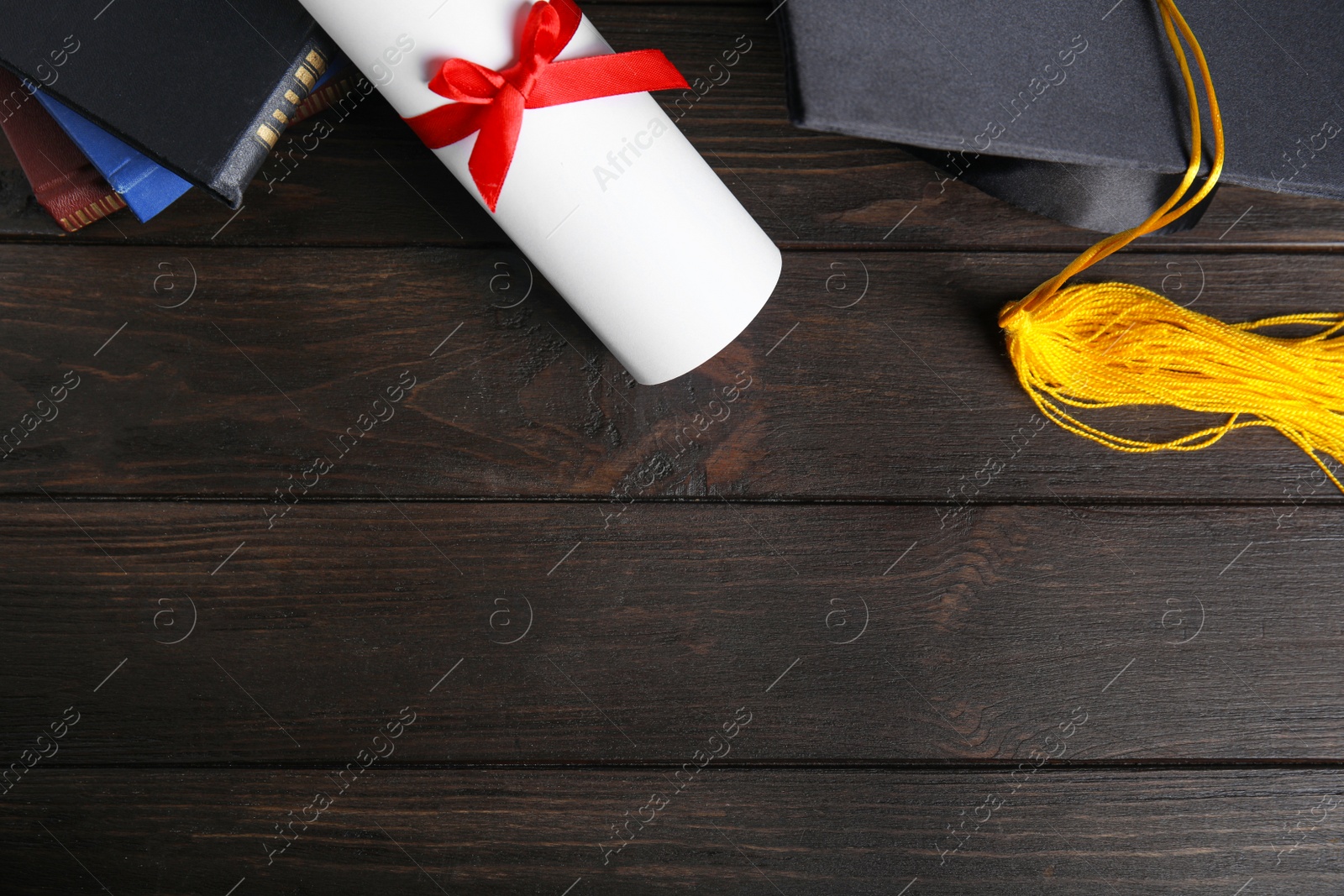 Photo of Flat lay composition with graduation hat and student's diploma on black wooden table, space for text