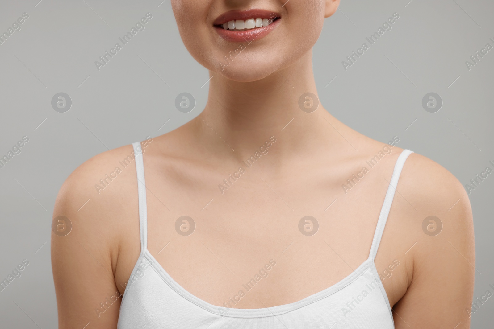 Photo of Beauty concept. Smiling woman on grey background, closeup