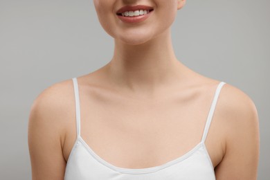 Photo of Beauty concept. Smiling woman on grey background, closeup