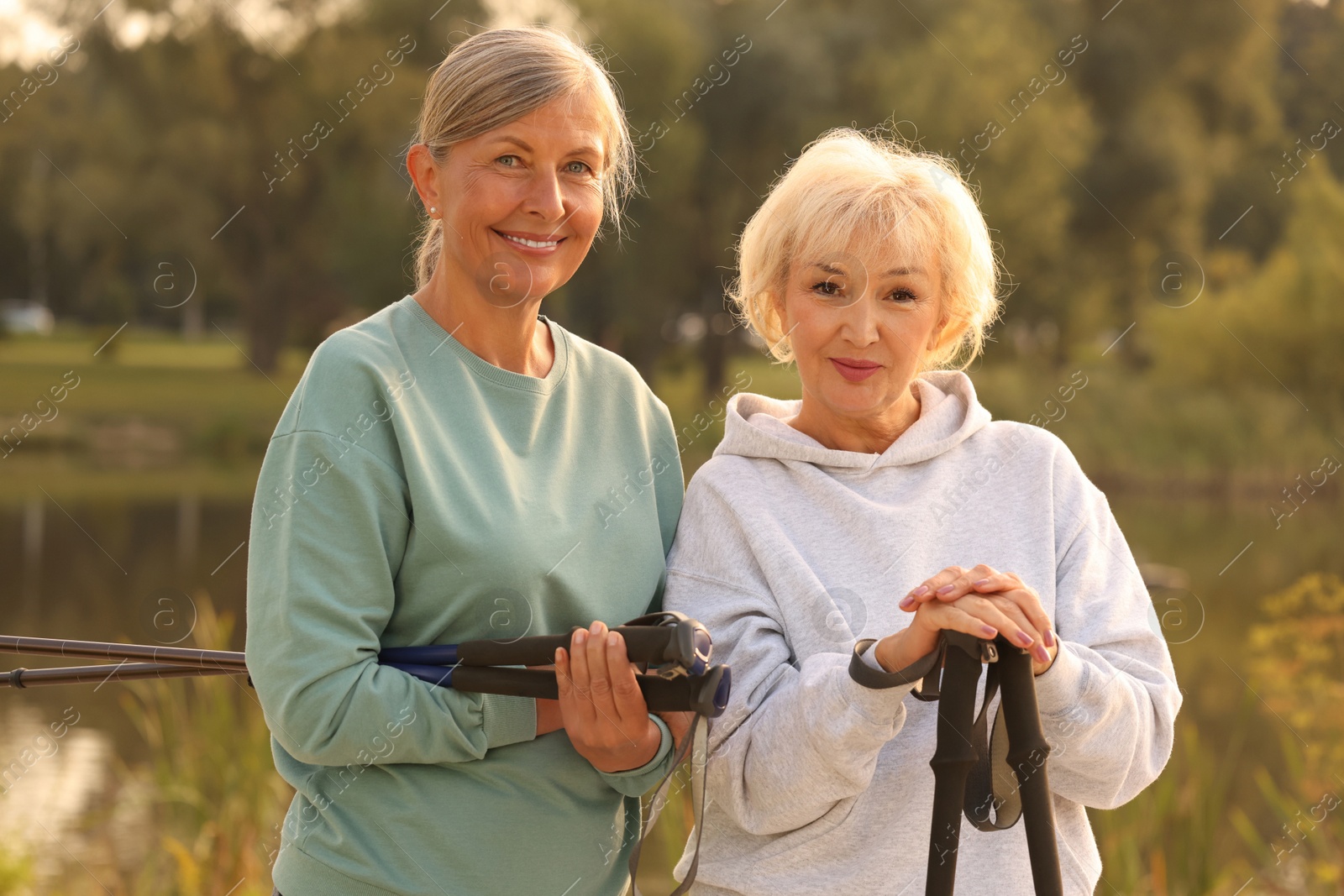 Photo of Two senior women with Nordic walking poles outdoors