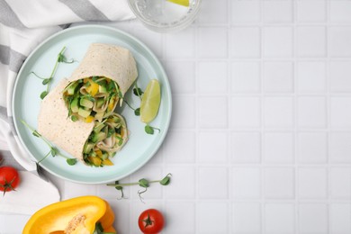 Photo of Delicious sandwich wraps with fresh vegetables, bell pepper, tomatoes and slice of lime on white tiled table, flat lay. Space for text