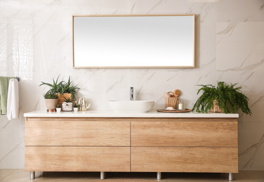 Stylish bathroom interior with countertop, mirror and houseplants. Design idea