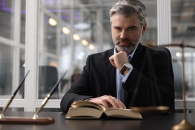 Portrait of confident lawyer at table in office