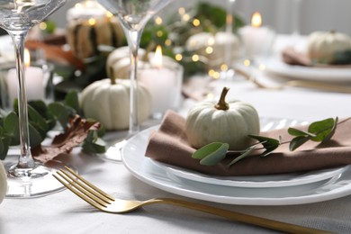 Photo of Beautiful autumn table setting, pumpkin and eucalyptus branch, closeup