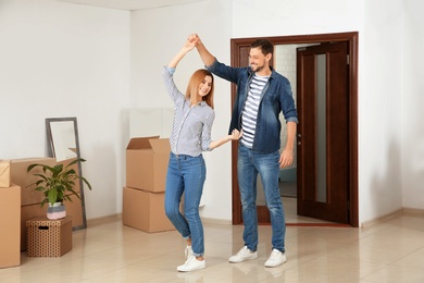 Couple dancing near moving boxes in their new house