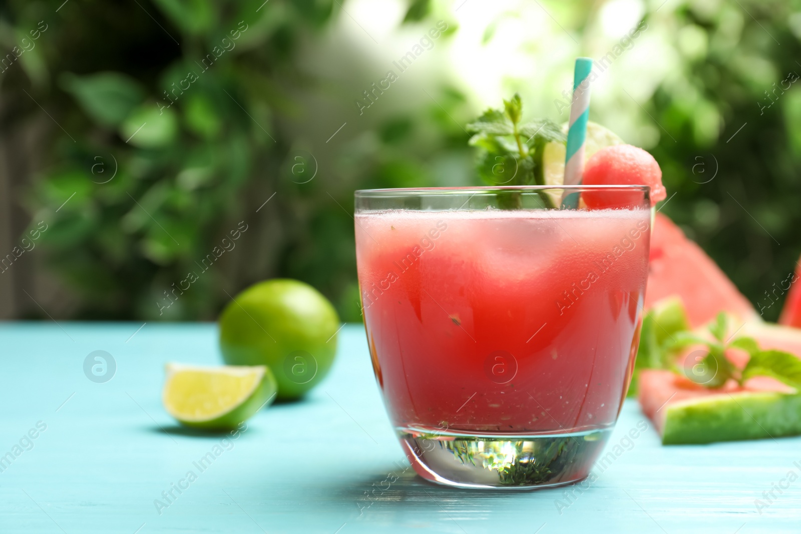 Photo of Delicious fresh watermelon drink on light blue wooden table