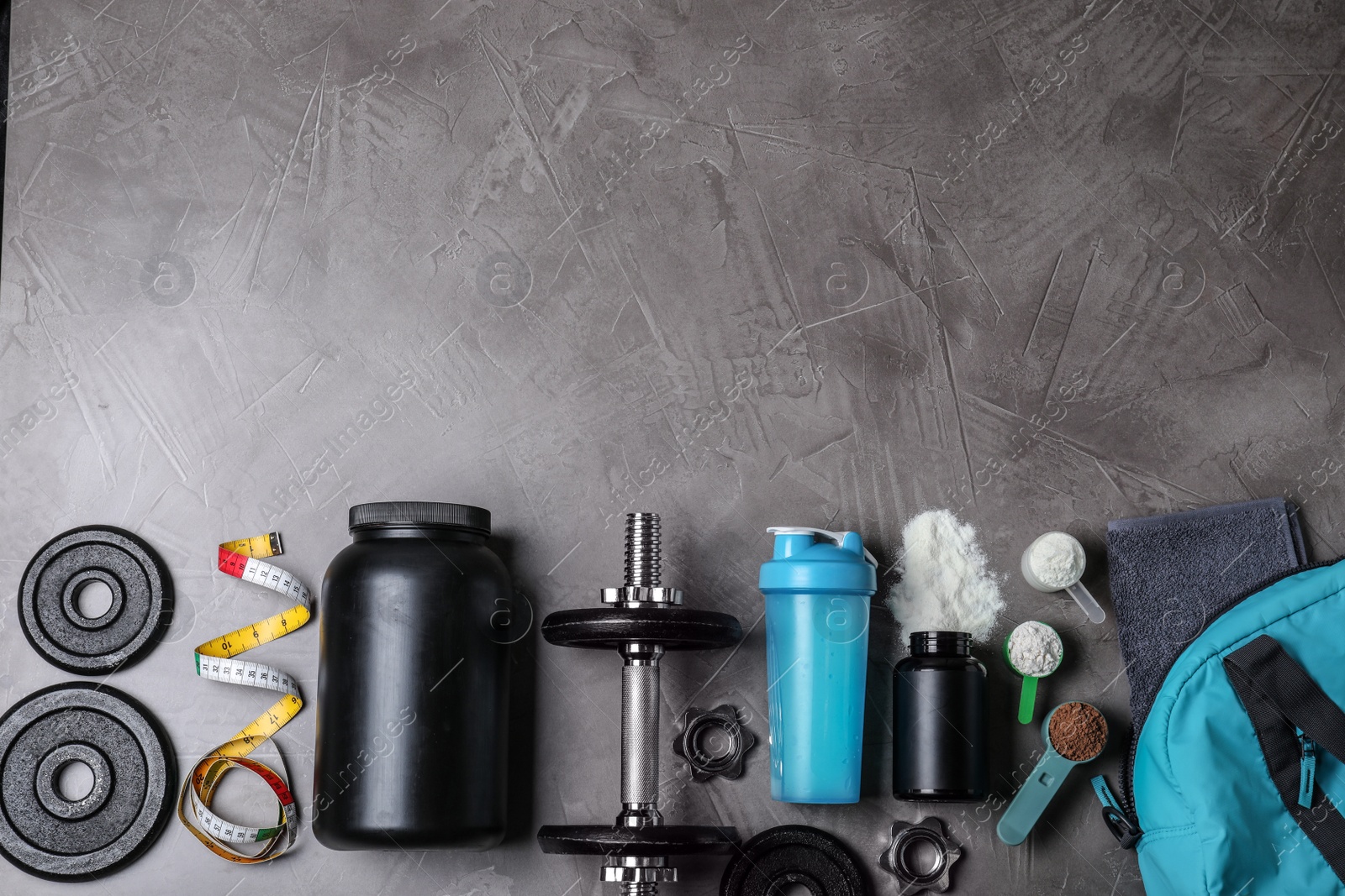 Photo of Flat lay composition with protein powder and fitness equipment on grey background. Space for text