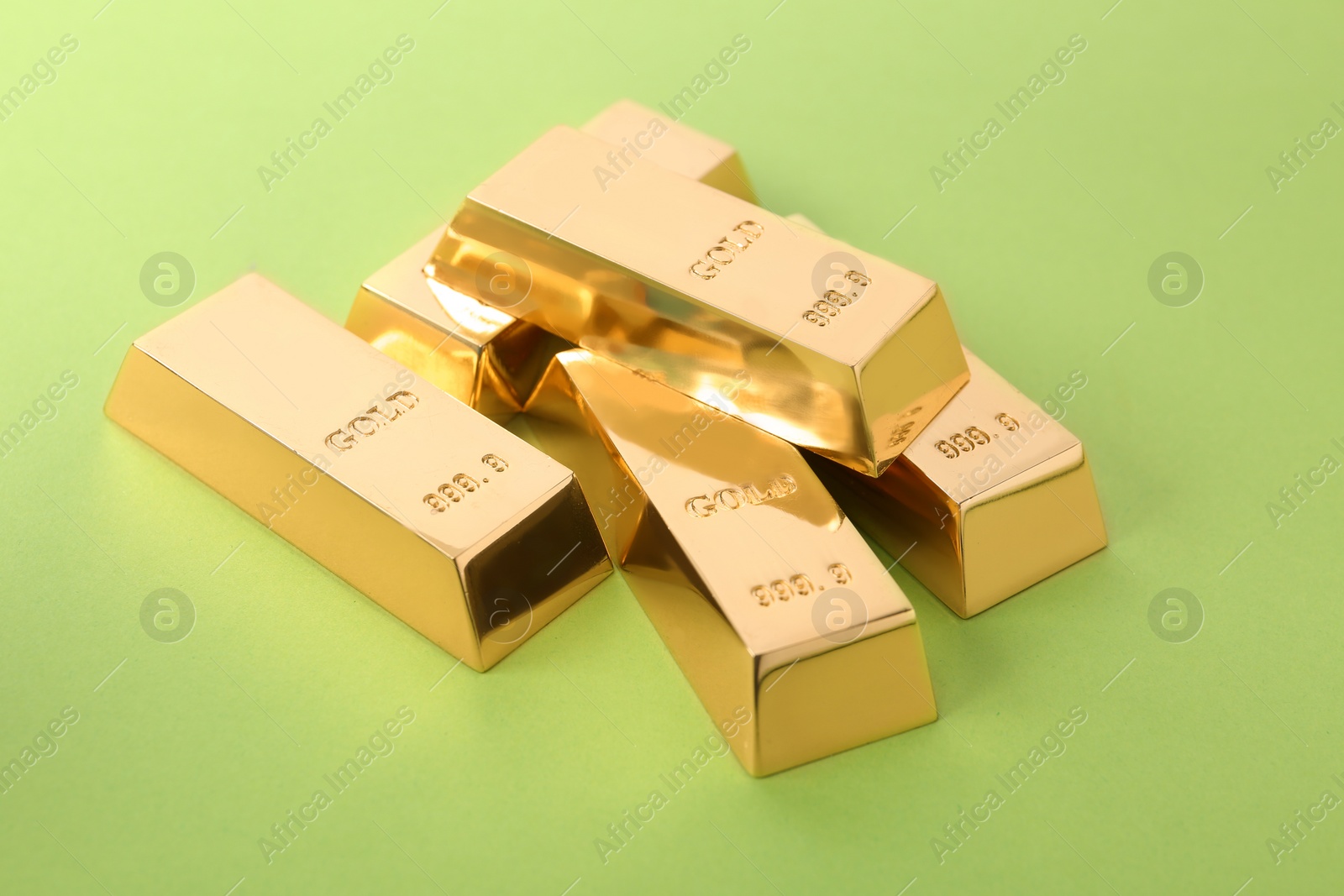 Photo of Precious shiny gold bars on color background