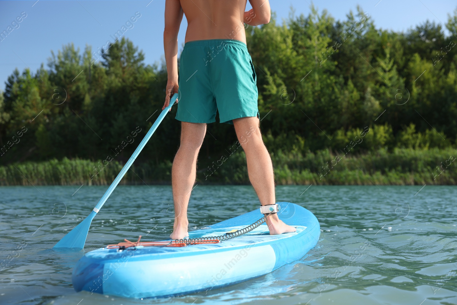 Photo of Man paddle boarding on SUP board in river, closeup