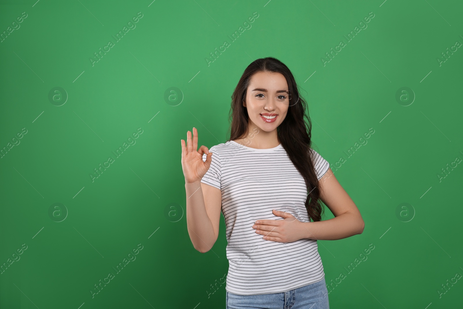 Photo of Happy healthy woman touching her belly on green background, space for text