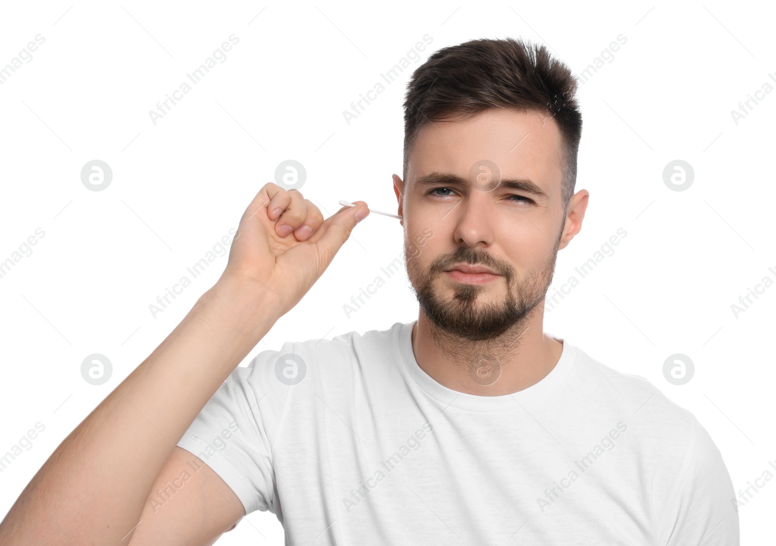 Photo of Young man cleaning ear with cotton swab on white background