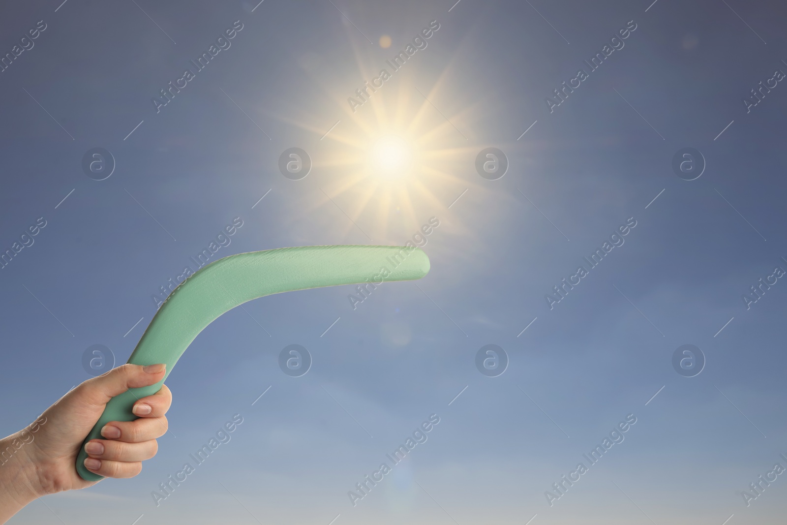 Image of Woman holding boomerang outdoors on sunny day, closeup 