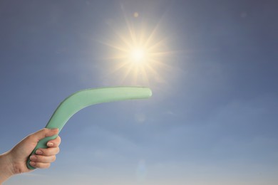 Woman holding boomerang outdoors on sunny day, closeup 