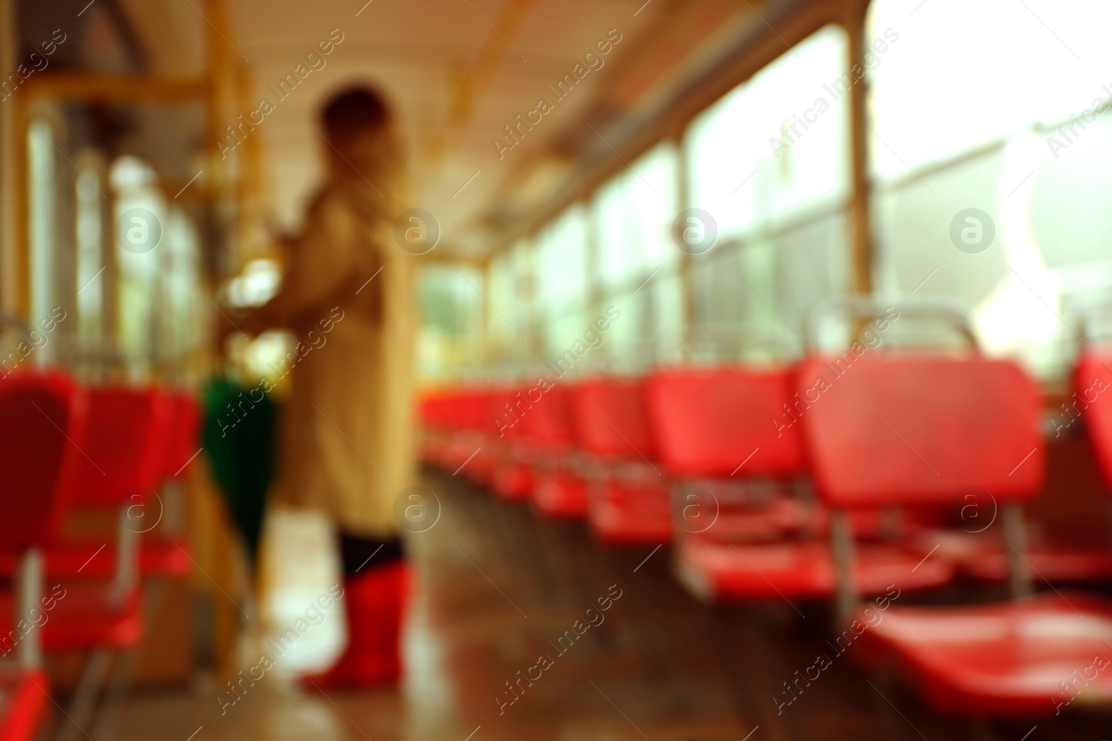 Photo of Blurred view of woman with umbrella in tram on rainy day