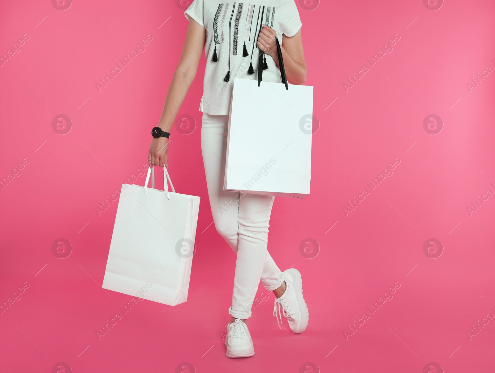 Photo of Woman with paper shopping bags on color background. Mock up for design