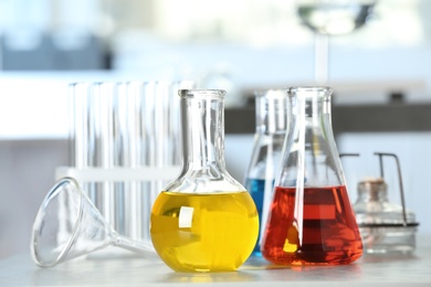 Laboratory glassware with different liquid samples on table