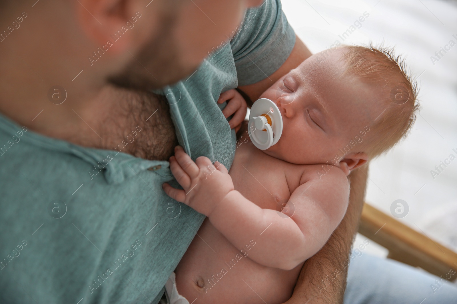 Photo of Father with his newborn son, closeup view