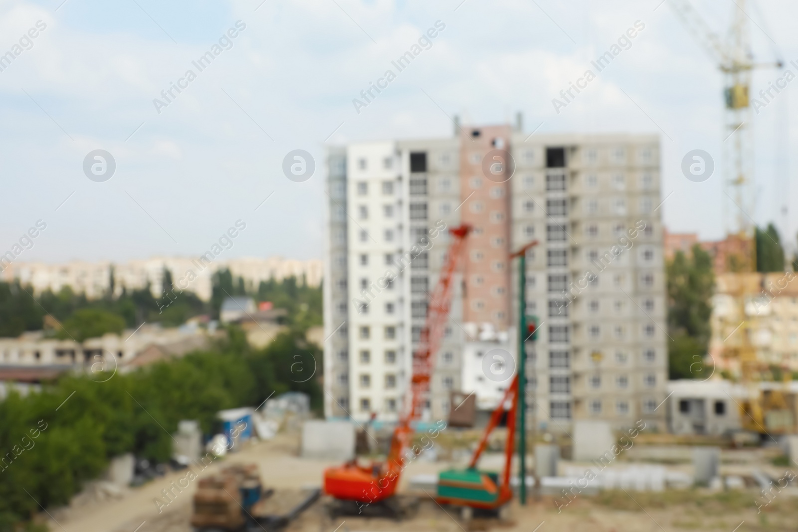 Photo of Blurred view of construction site with heavy machinery near unfinished building