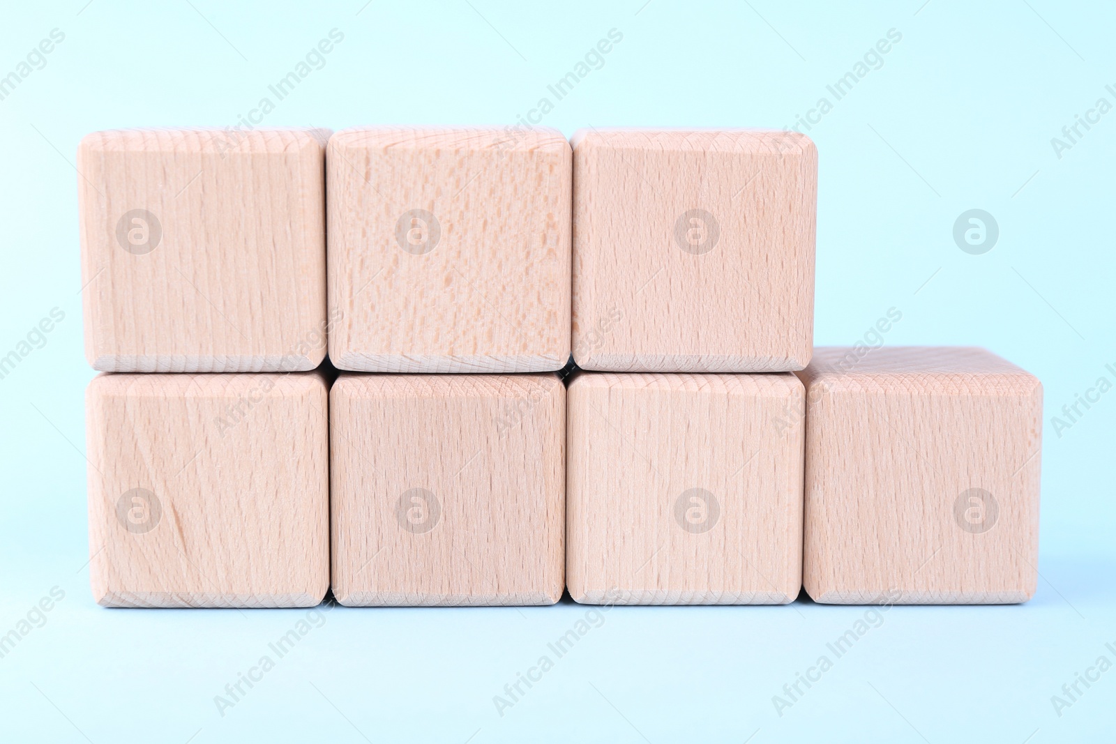 Photo of International Organization for Standardization. Wooden cubes with abbreviation ISO and number 9001 on light blue background, closeup