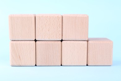 International Organization for Standardization. Wooden cubes with abbreviation ISO and number 9001 on light blue background, closeup