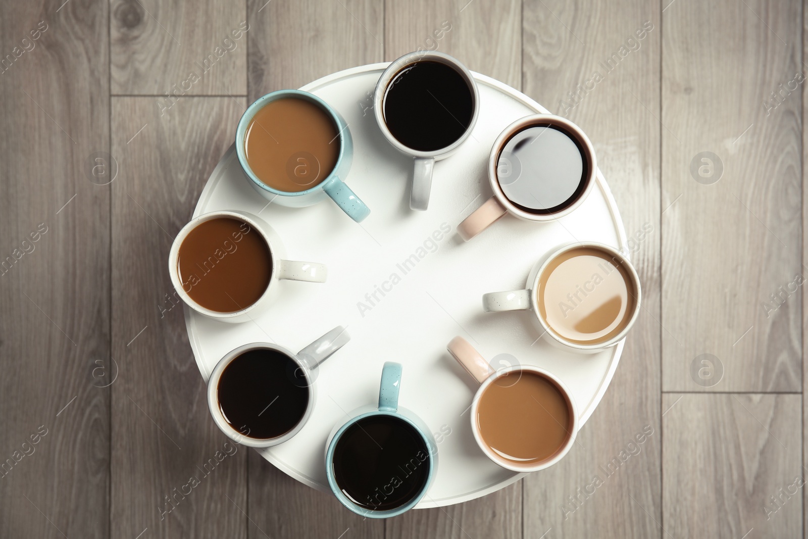 Photo of Cups of fresh aromatic coffee on light table, top view. Food photography