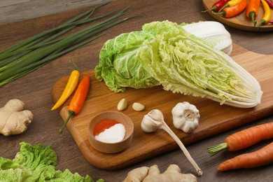 Photo of Fresh Chinese cabbages and ingredients on wooden table