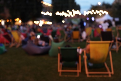 Blurred view of modern open air cinema with comfortable seats in public park