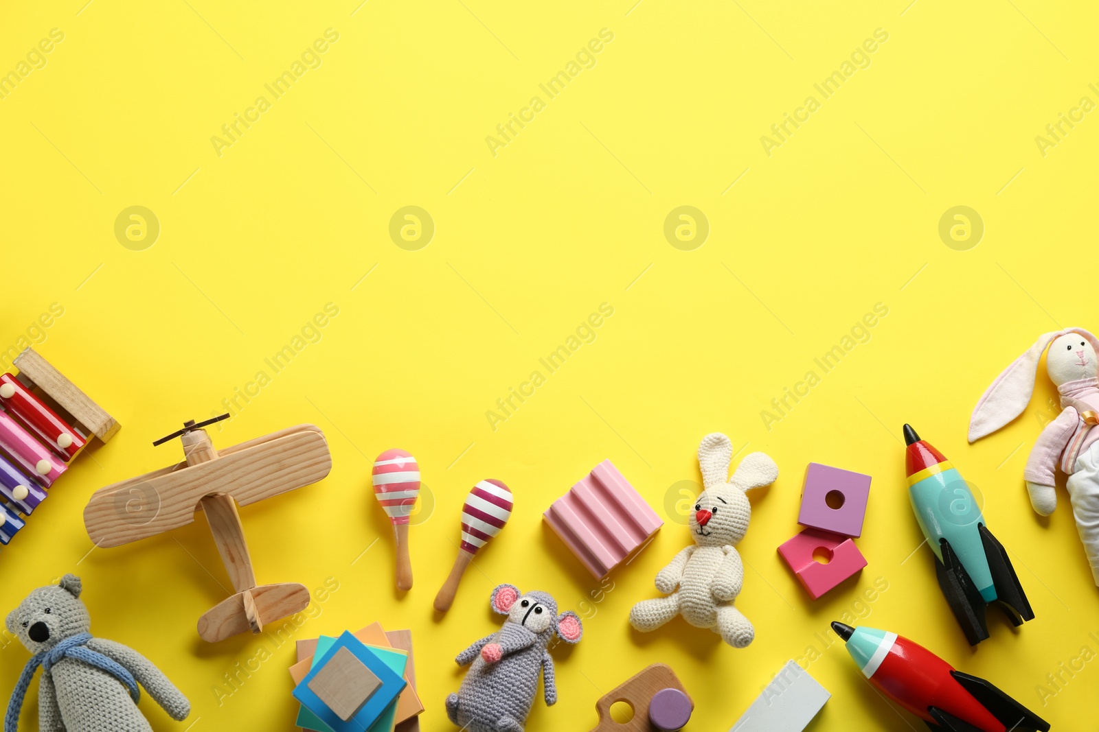 Photo of Flat lay composition with different toys on yellow background. Space for text