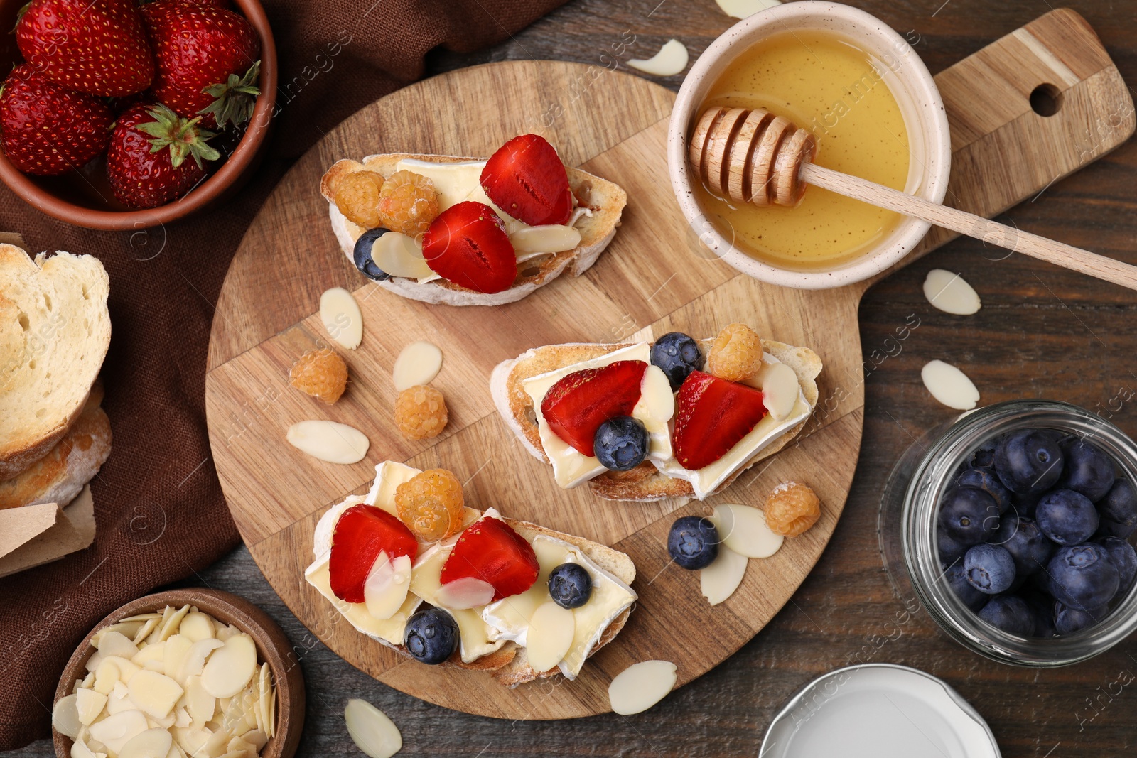 Photo of Tasty brie cheese sandwiches on wooden table, flat lay