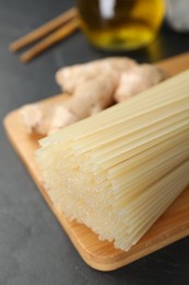 Dried rice noodles with ginger on black table, closeup
