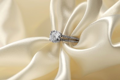 Beautiful ring with gemstones on white fabric. Luxury jewelry