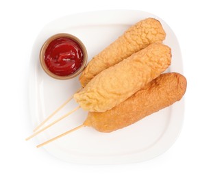 Delicious deep fried corn dogs with ketchup on white background, top view