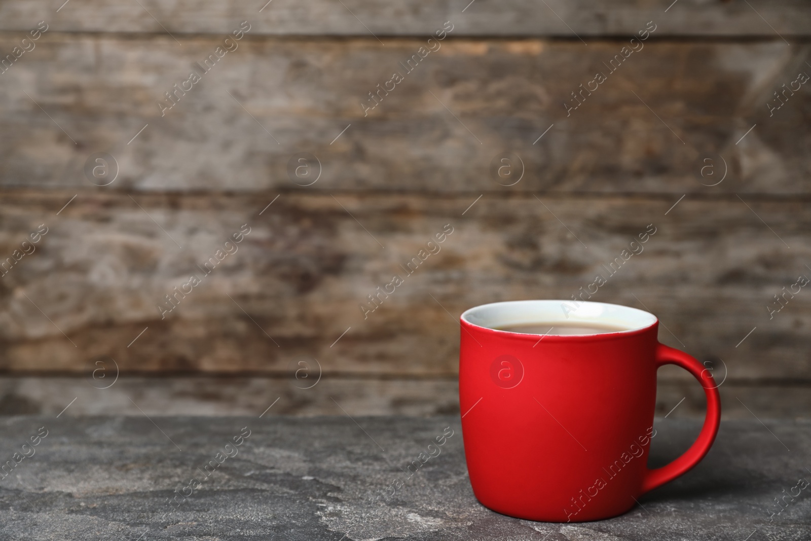 Photo of Red ceramic cup with hot aromatic coffee on table