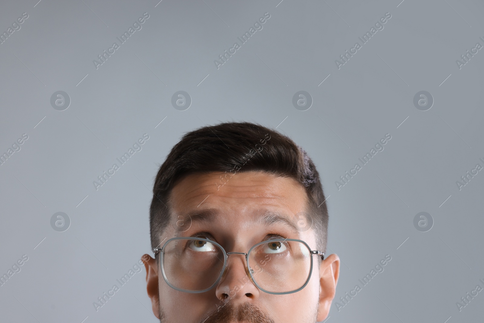 Photo of Man in stylish glasses on light grey background, closeup