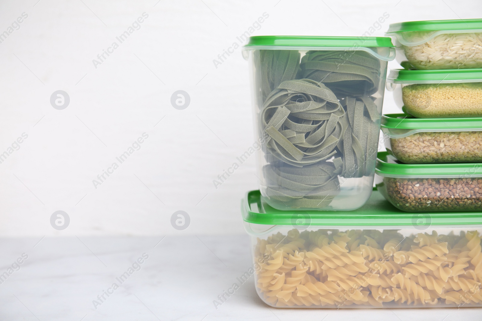 Photo of Plastic containers filled with food products on white table. Space for text