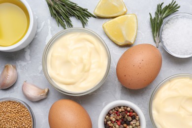 Photo of Delicious homemade mayonnaise, spices and ingredients on grey table, flat lay