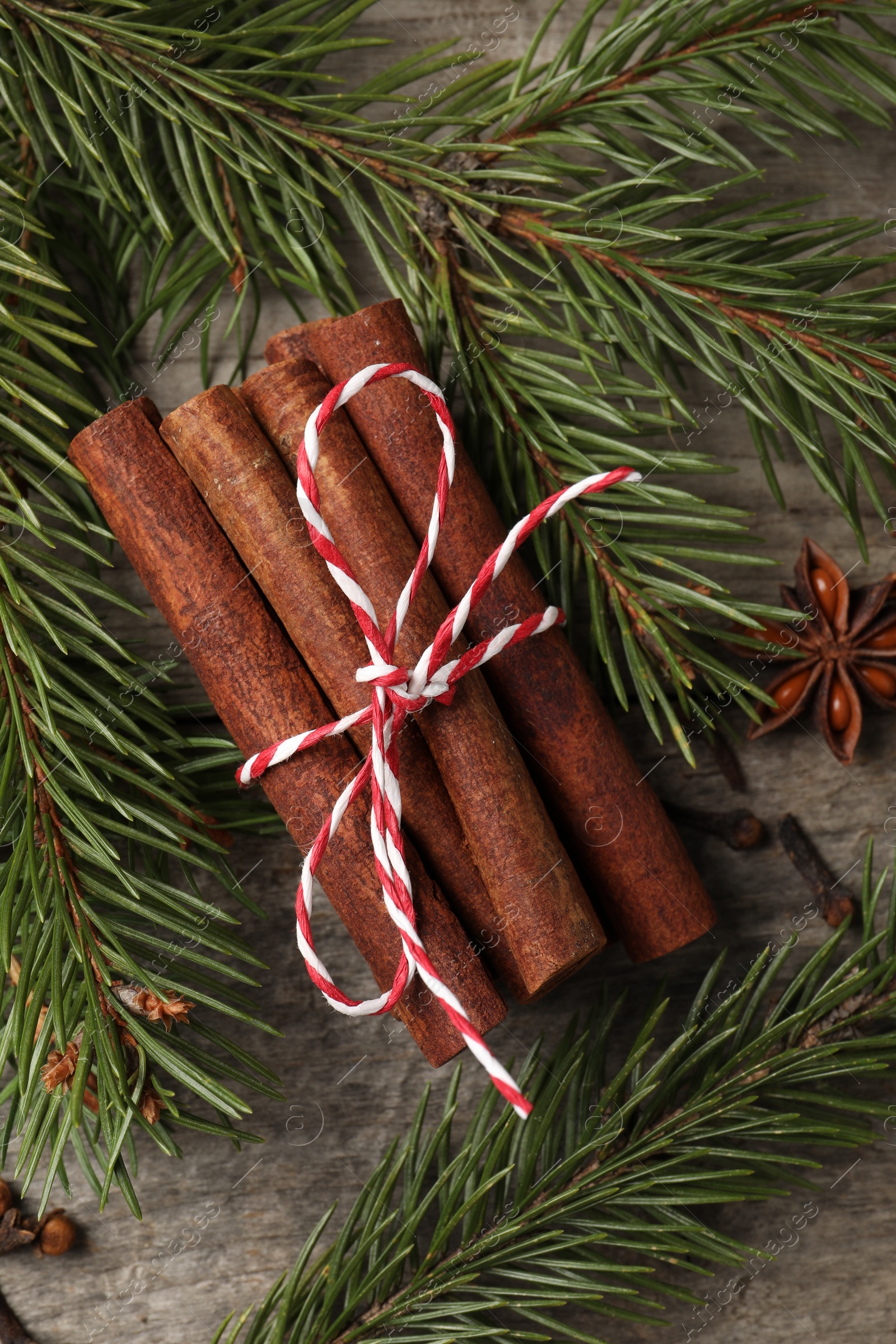 Photo of Different spices and fir branches on wooden table, flat lay