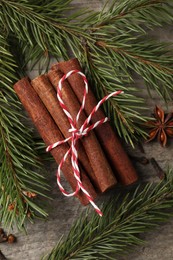 Different spices and fir branches on wooden table, flat lay